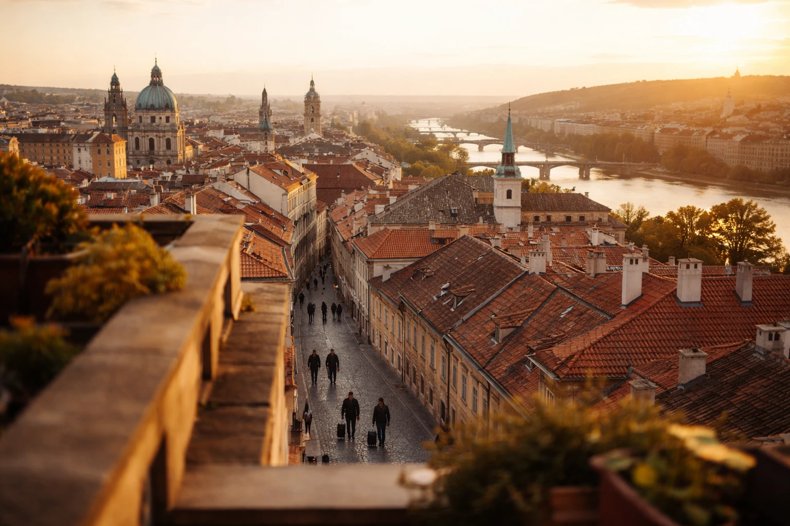 Skyline di una città europea al tramonto visto da una terrazza, con viaggiatori con bagagli che camminano su una strada di pietra sottostante